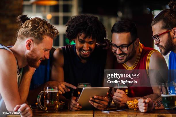 männliche freunde beobachten spiel auf tablet - sports betting stock-fotos und bilder