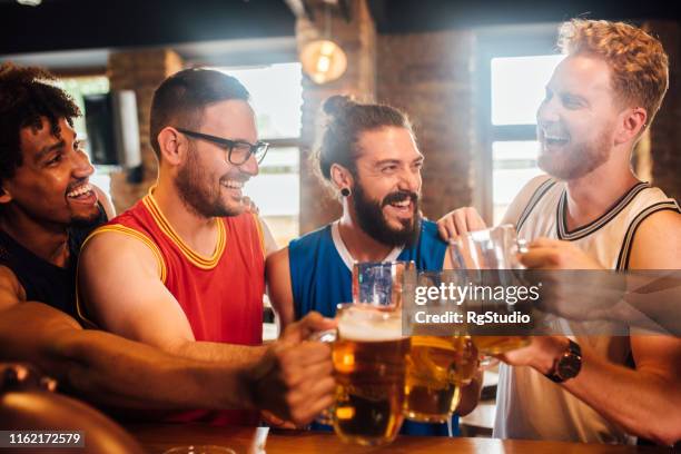 happy men drinking beer - crowd cheering bar stock pictures, royalty-free photos & images