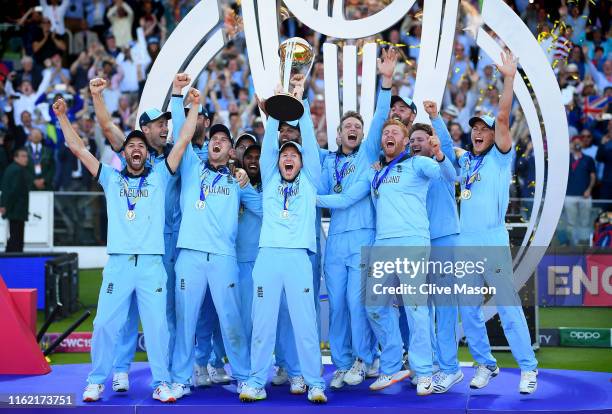 Eoin Morgan of England celebrates with his team as he lifts the Cricket World Cup trophy after the Final of the ICC Cricket World Cup 2019 between...