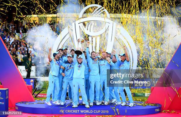 Eoin Morgan of England celebrates with his team as he lifts the Cricket World Cup trophy after the Final of the ICC Cricket World Cup 2019 between...