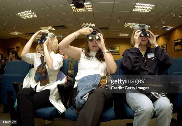 Marcie Todaro Kellie Hill and Kim Helgeson learn how to use a pair of night vision goggles during a spouse's orientation day at the 37th Airlift...