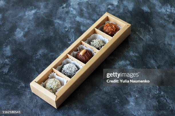 set of chocolate candies in a box. exclusive handmade bonbons. top view, copy space, dark background. - chocolate top view stock-fotos und bilder