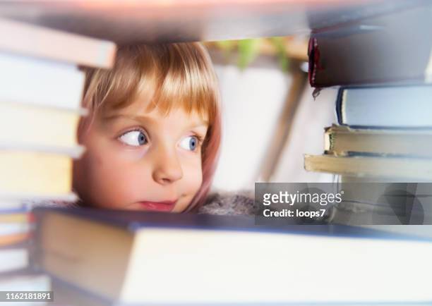 girl looking at heap of books - large group of objects stock pictures, royalty-free photos & images