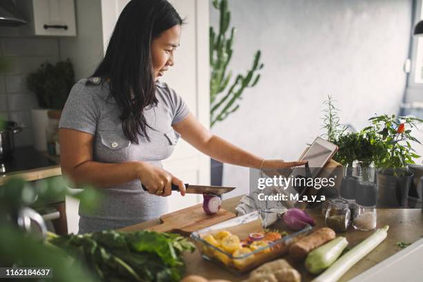 hacer comida saludable - mujer cocinando fotografías e imágenes de stock