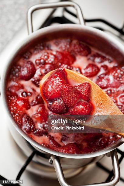 aardbei jam, koken aardbei marmelade, - preserves stockfoto's en -beelden