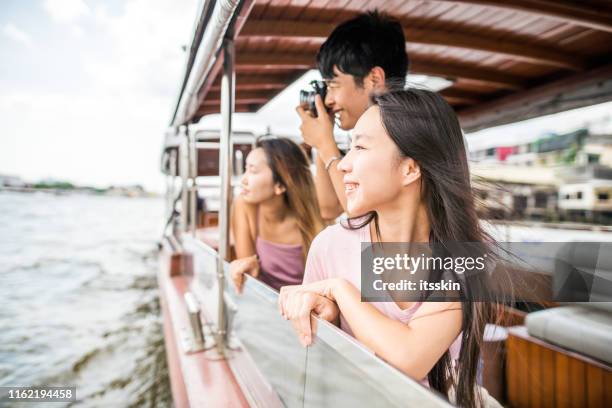asiatische freunde auf der flusstour in bangkok neben wat arun - ausflugsboot stock-fotos und bilder