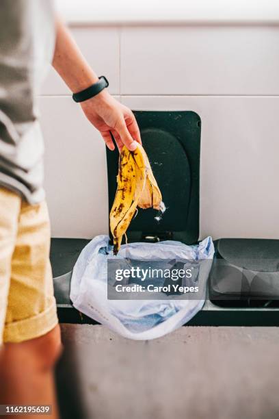 hand putting organic garbage in the bin at kitchen - banana peel stock pictures, royalty-free photos & images