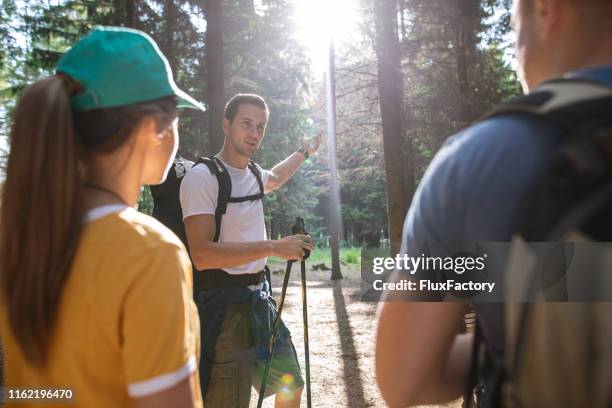 hiking expert suggesting his friends where to head next - head mount display stock pictures, royalty-free photos & images