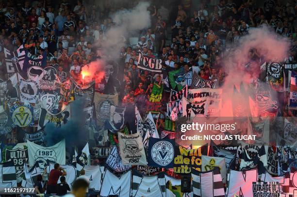 Bordeaux's fans light flares during the French L1 football match between FC Girondins de Bordeaux and Montpellier on August 17 at the Matmut...