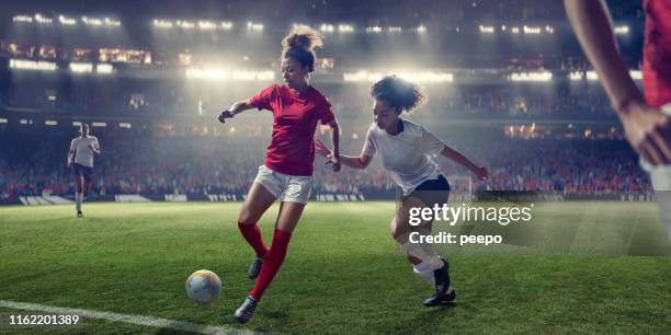 gioca a calcio femminile a metà gara durante la partita nello stadio illuminato - calcio femminile foto e immagini stock