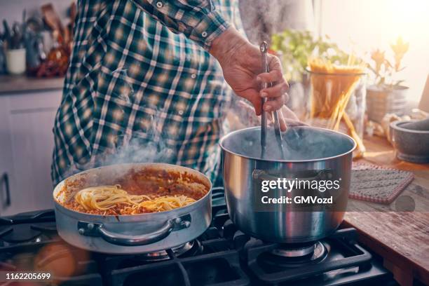 preparing spaghetti bolognese in domestic kitchen - grated cheese stock pictures, royalty-free photos & images