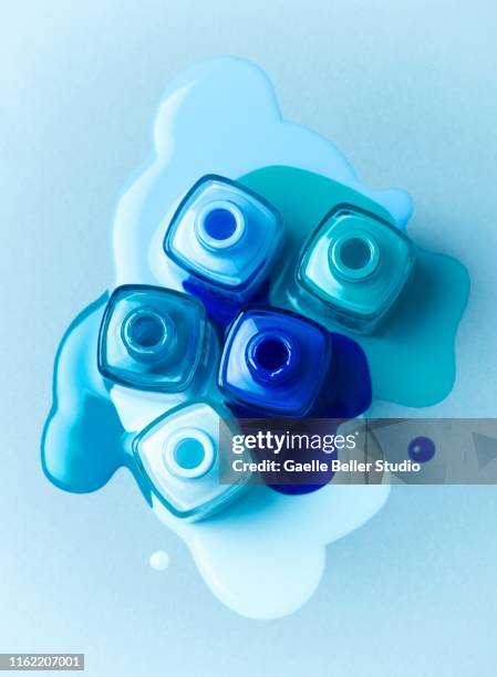 abstract composition of blue colored nail polish bottles - esmalte cosmético - fotografias e filmes do acervo