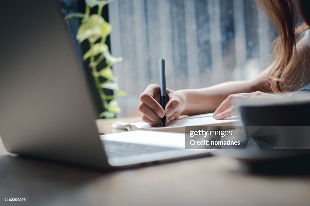 Hand holding pen and writing on paper.Listing on paper concept.