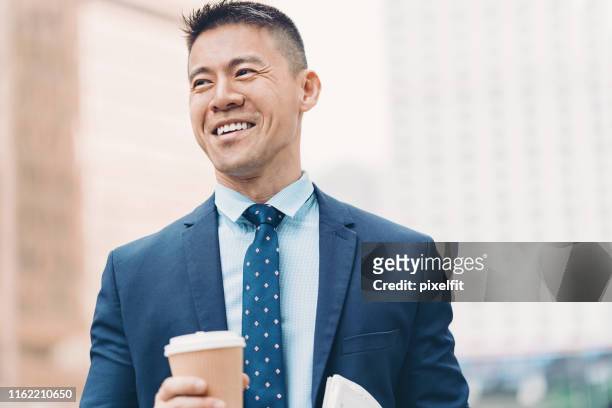 lächelnder asiatischer geschäftsmann - asien happiness porträt mann stock-fotos und bilder