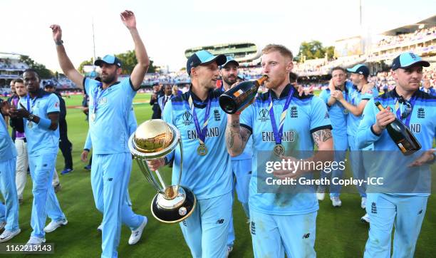 Joe Root and Ben Stokes of England celebrate with the trophy after winning the Final of the ICC Cricket World Cup 2019 between New Zealand and...