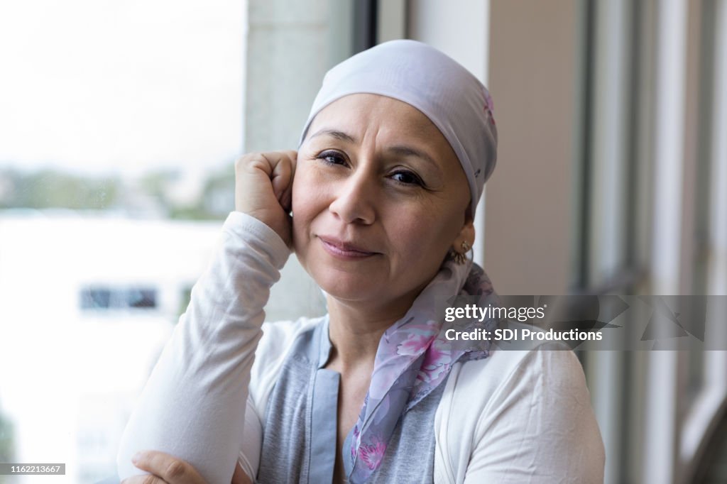 Cancer patient wearing a scarf to cover head looks peaceful