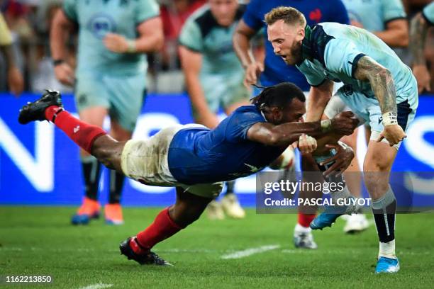 Scotland's winger Byron McGuigan is tackled by France's winger Alivereti Raka during the 2019 Rugby World Cup warm-up test match between France and...