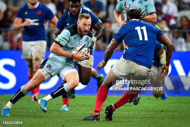 Scotland's winger Byron McGuigan is tackled by France's winger Alivereti Raka during the 2019 Rugby World Cup warm-up test match between France and...