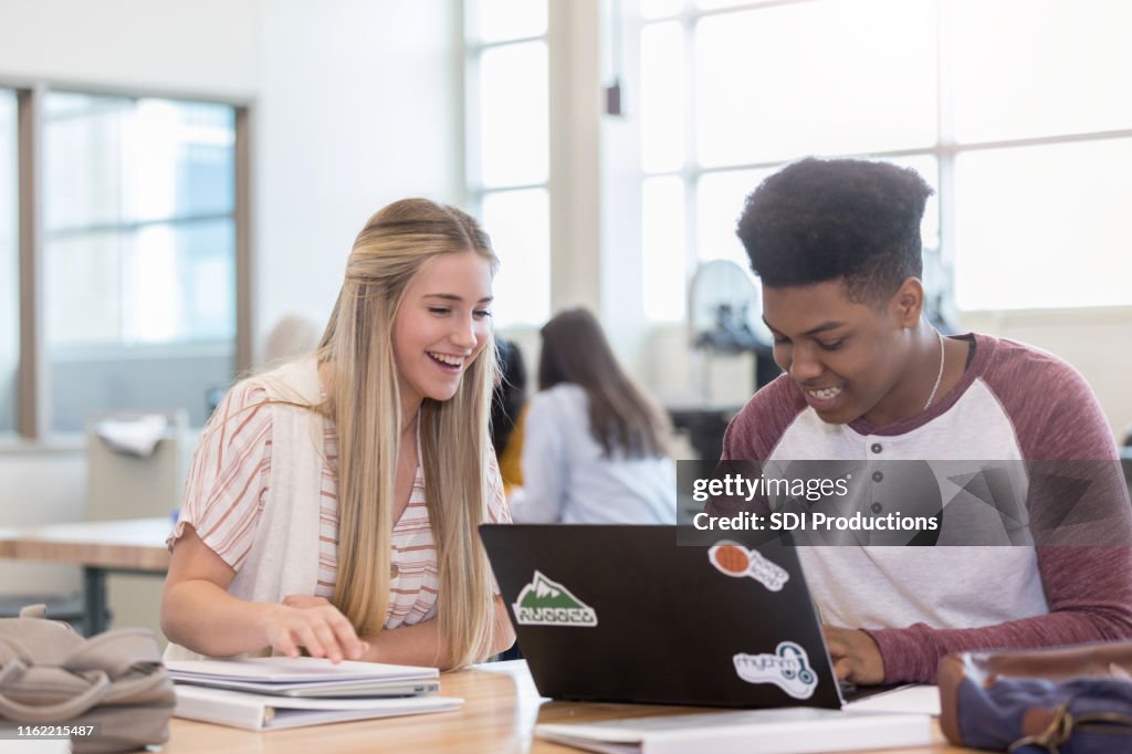 Cheerful high school students studying together