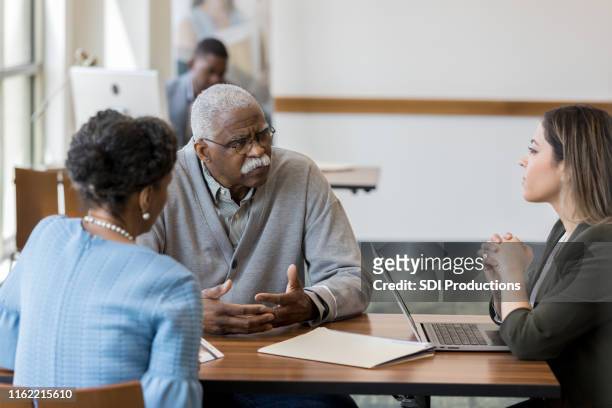 senior couple meet with loan officer - bank manager meeting stock pictures, royalty-free photos & images