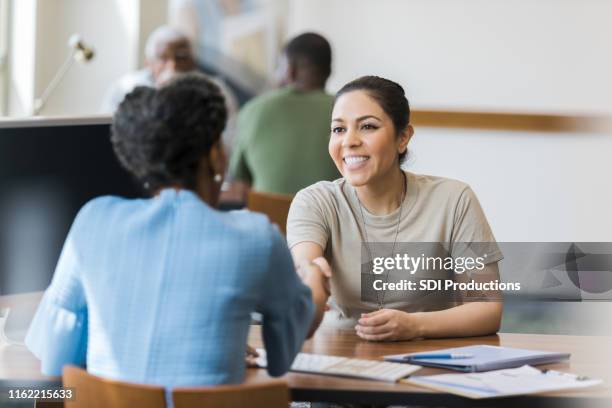 cheerful females soldier greets bank manager - veteran stock pictures, royalty-free photos & images