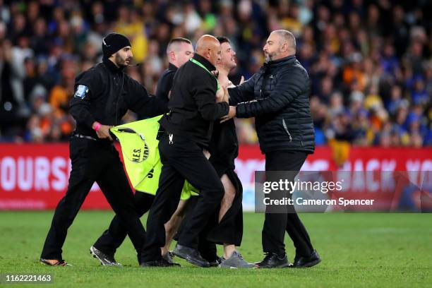 Streaker is apprehended during the round 17 NRL match between the Wests Tigers and the Parramatta Eels at Bankwest Stadium on July 14, 2019 in...