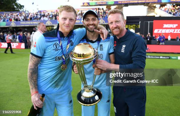 Ben Stokes and Mark Wood of England celebrates with coach Paul Collingwood and the trophy after winning the Final of the ICC Cricket World Cup 2019...