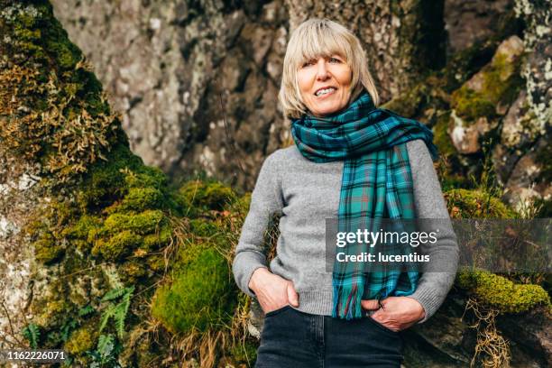 woman wearing tartan scarf in natural environment - plaid scarf stock pictures, royalty-free photos & images