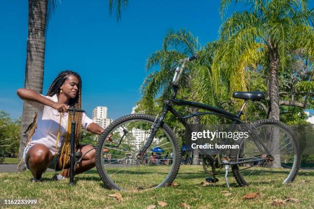 a mulher enche o pneu da bicicleta - inflating - fotografias e filmes do acervo