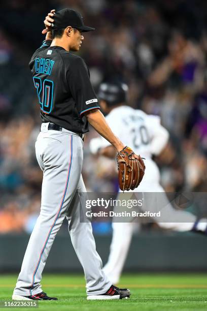 Wei-Yin Chen of the Miami Marlins reacts after allowing back-to-back home runs to the Colorado Rockies as Ian Desmond of the Colorado Rockies rounds...