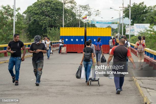 People seen walking with their luggage over the SImon Bolivar bridge at the Venezuela Colombia border crossing in Cucuta. Thousands of Venezuelans...