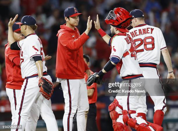 Shohei Ohtani of the Los Angeles Angels high-fives catcher Anthony Bemboom after a 6-5 win over the Chicago White Sox on Aug. 17 at Angel Stadium in...