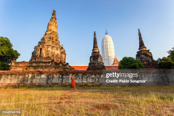 young novice monk walking at wat phutthai sawan temple - ayuthaya stock pictures, royalty-free photos & images