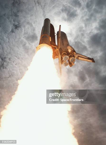 Space Shuttle Columbia after take-off on its 12th mission, soaring into a cloudy sky after lift-off from Kennedy Space Center, Florida, USA, 7...