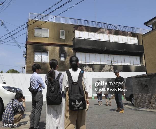 People visit the burnt-out, three-story studio of Kyoto Animation Co. In western Japan on Aug. 18 one month after an arson attack killed 35 people....