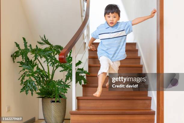 young boy jumping and flying off some stairs - child running up stairs stock pictures, royalty-free photos & images