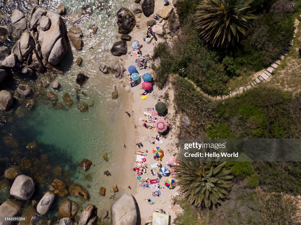 Aerial shot of a beautiful beach cove with people on the beach