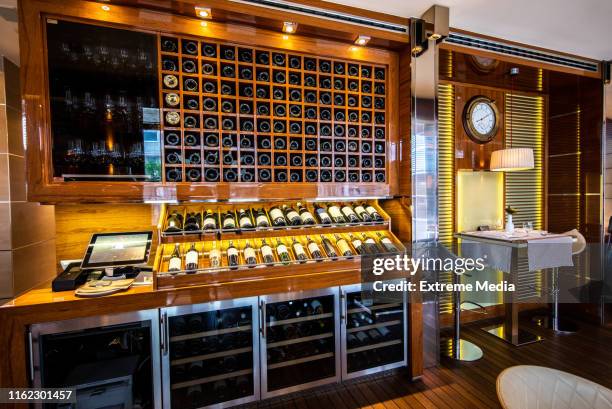 wine showcase cabinet and shelf with wine bottles standing on display in a high class restaurant - wine bottle transport stock pictures, royalty-free photos & images