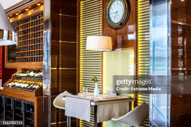 a table with two seats next to a wine display in a luxurious restaurant - dinner boat imagens e fotografias de stock