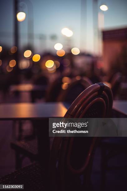 empty seat at outdoor area of restaurant during dawn - focus on foreground stock pictures, royalty-free photos & images
