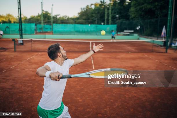 tennis players playing a match outdoors - tennis player stock pictures, royalty-free photos & images