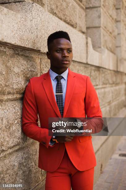 Portrait of young South African man in a red suit standing outdoors