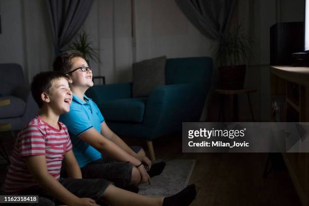 boys watching a movie at home at night - home movie stock pictures, royalty-free photos & images