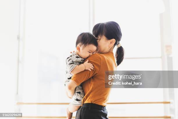 mutter umarmt ihr baby - japanese mom stock-fotos und bilder