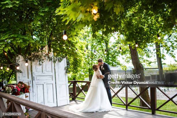 newlyweds kiss on reception area - ceremony stock pictures, royalty-free photos & images