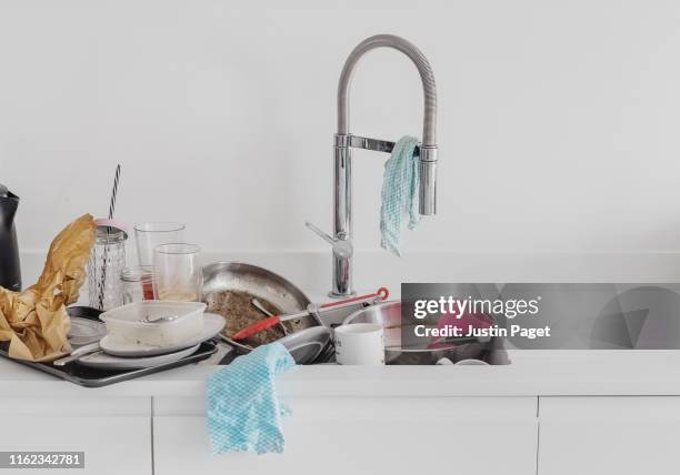 pile of dirty dishes in kitchen sink - trapo de limpiar el polvo fotografías e imágenes de stock