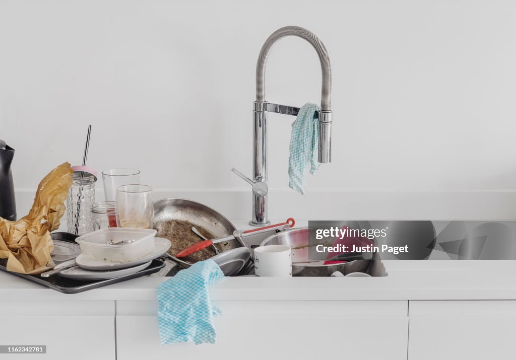 Pile of dirty dishes in kitchen sink