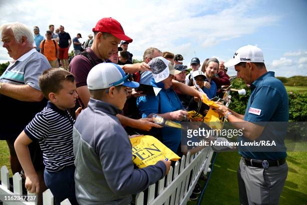 Padraig Harrington of Ireland signs autographs to fans during a practice round prior to the 148th Open Championship held on the Dunluce Links at...