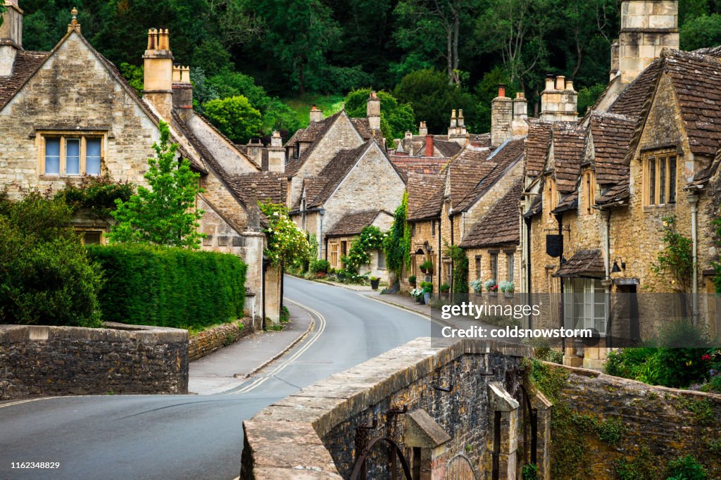 Pueblo tradicional idílico de la campiña inglesa con cabañas acogedoras y carretera estrecha