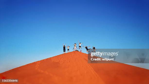 group of 7 red sand dune jump - sand boarding stock pictures, royalty-free photos & images